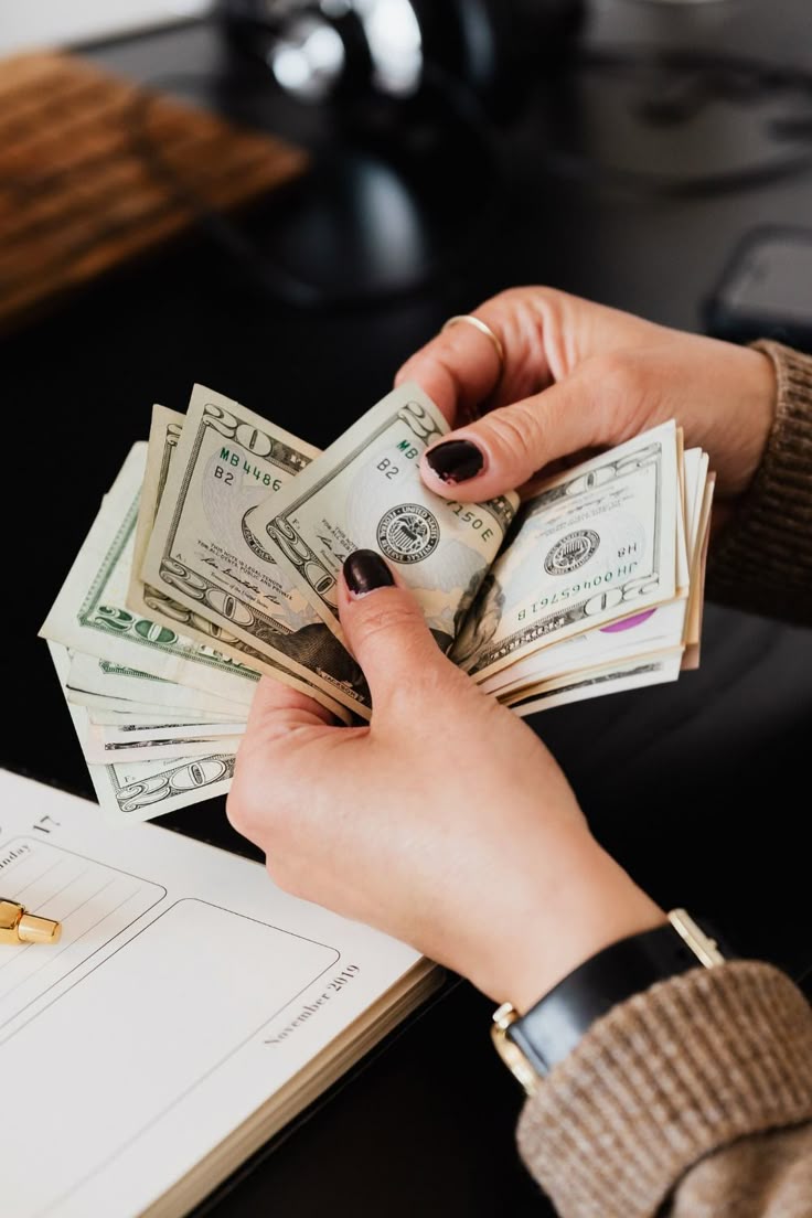 Hands counting money representing competitive compensation